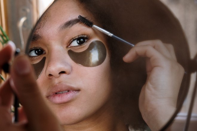 Girl applying makeup to eyebrow