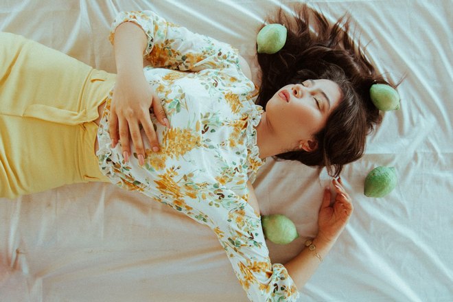 Girl sleeps surrounded by citrus fruits