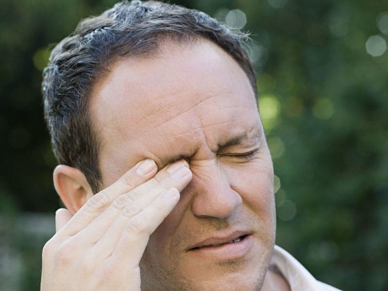 Photo of a man scratching his eyebrow