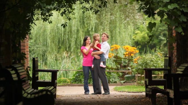 Счастливая семейная пара в саду с хвоей